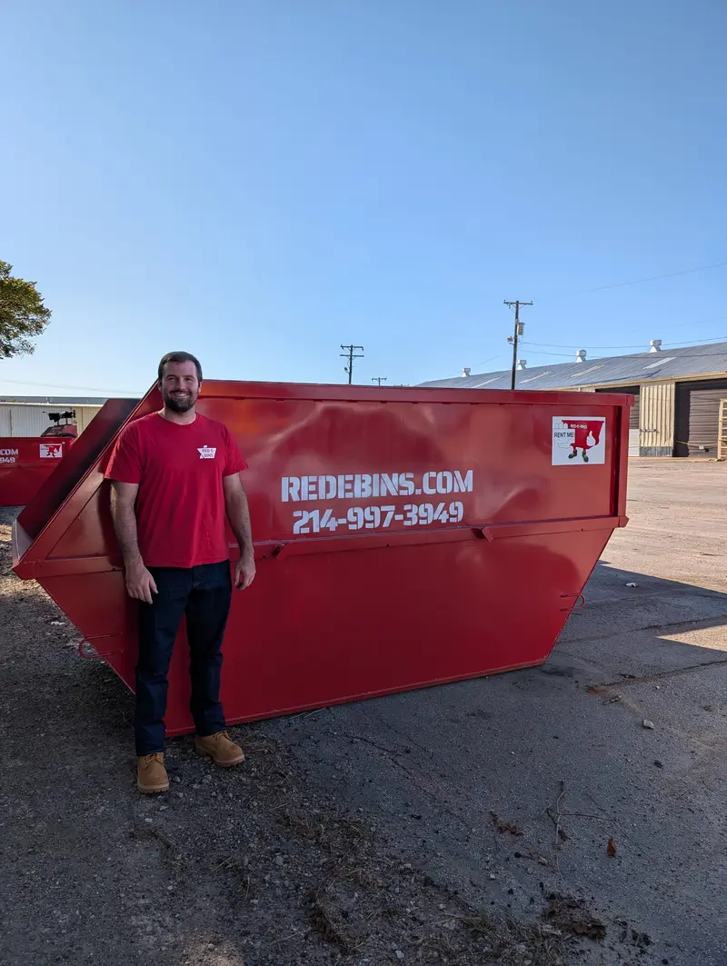 15-yard Red-E-Bins dumpster with a team member beside it