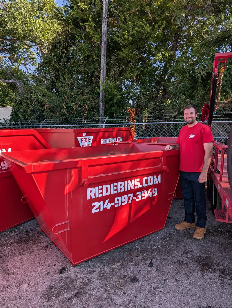5-yard Red-E-Bins dumpster with a team member beside it